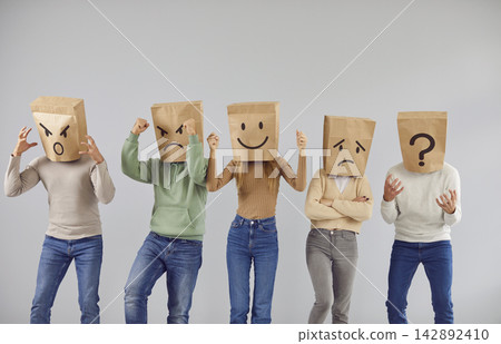Group of people expressing different emotions wearing brown paper bags on their heads 142892410