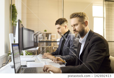 Two business analysts accountants team working on finance data in modern office Two business analysts accountants team working on finance data in modern office 142892413