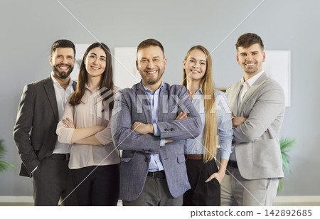 Successful young business team standing with arms crossed in office and looking at camera. Successful young business team standing with arms crossed in office and looking at camera. 142892685