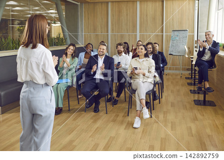 Happy diverse audience applauding speaker after presentation at business seminar Happy diverse audience applauding speaker after presentation at business seminar 142892759