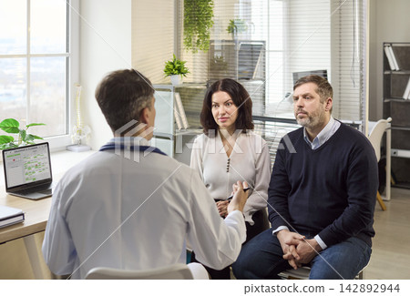 Doctor consulting couple in clinic about family planning and fertility guidance Doctor consulting couple in clinic about family planning and fertility guidance 142892944