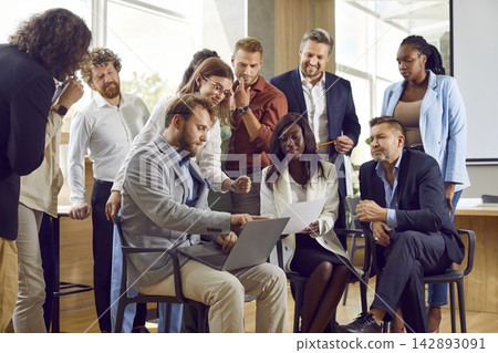 Team of diverse business men and women using laptop during work meeting in office 142893091