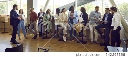 Business people chatting after meeting. Company employees talking in office. Business people chatting after meeting. Company employees talking in office. 142893166