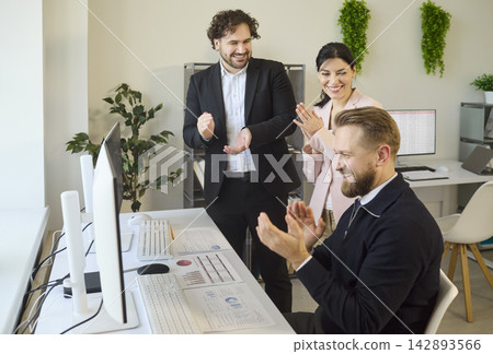 Happy colleagues celebrating achievement after successful office analytics results 142893566