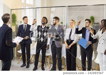 Diverse team raising hands during office meeting and collaborative planning Diverse team raising hands during office meeting and collaborative planning 142893567
