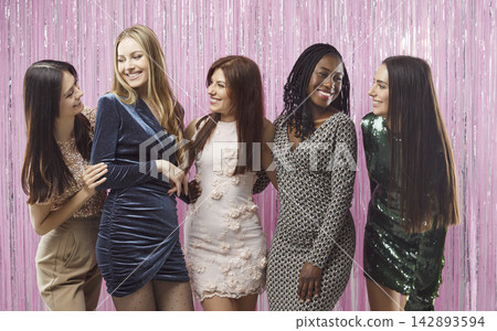Diverse cheerful female friends in dress clothes talking enjoying party together 142893594