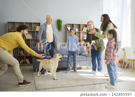 Cheerful parents children and grandparents play with Labrador dog in cozy home Cheerful parents children and grandparents play with Labrador dog in cozy home 142893597