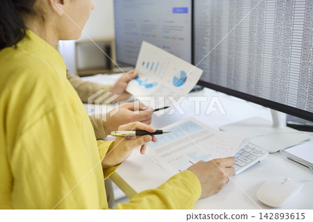 Accountants analyzing finance data and spreadsheets in modern office with charts Accountants analyzing finance data and spreadsheets in modern office with charts 142893615