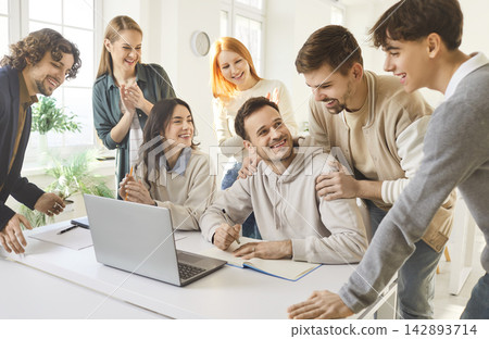 Diverse students collaborating on group project with laptop in bright study space Diverse students collaborating on group project with laptop in bright study space 142893714