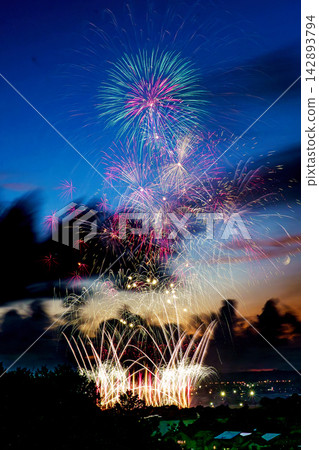 Green and white fireworks overlapping the blue evening sky Green and white fireworks overlapping the blue evening sky 142893794