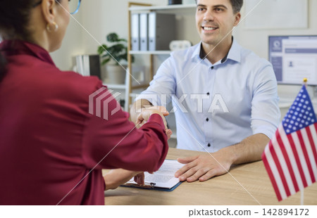Client and immigration consultant handshake confirming approved visa meeting Client and immigration consultant handshake confirming approved visa meeting 142894172