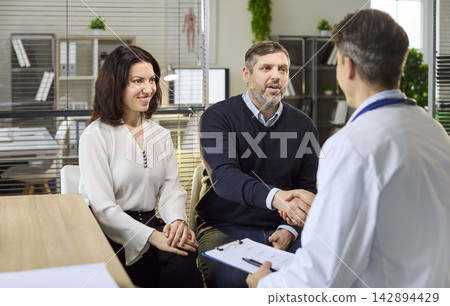 Couple meeting doctor in clinic for pregnancy planning consultation and advice Couple meeting doctor in clinic for pregnancy planning consultation and advice 142894429