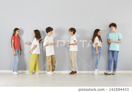 Group Of Children Communicating On Grey Background Group Of Children Communicating On Grey Background 142894433