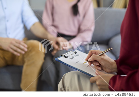 Couple with therapist in counseling session, closeup of notes and support Couple with therapist in counseling session, closeup of notes and support 142894635