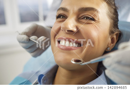 Close-up portrait of female patient lying in modern dentistry clinic in medical center. Close-up portrait of female patient lying in modern dentistry clinic in medical center. 142894685