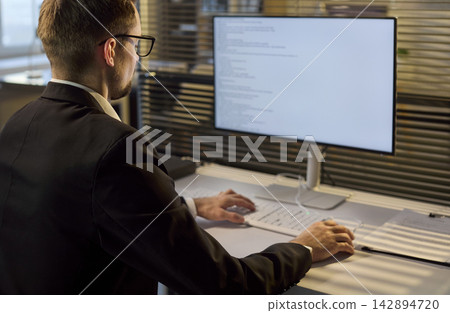 Business developer coding software on monitor in bright office workspace 142894720