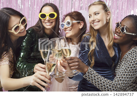 Happy multiracial friends girls fun wearing sun glasses, women drinking champagne at club Happy multiracial friends girls fun wearing sun glasses, women drinking champagne at club 142894737