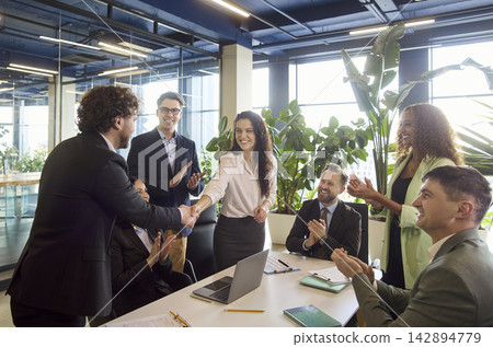 Diverse business team applauding handshake after successful office meeting 142894779