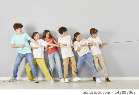 Students Pulling Rope Together On Grey Background Students Pulling Rope Together On Grey Background 142895062