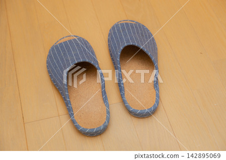Blue slippers lined up on the wooden floor Blue slippers lined up on the wooden floor 142895069