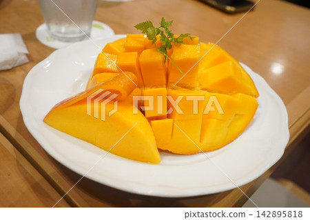 Mangoes beautifully cut and arranged on a white plate Mangoes beautifully cut and arranged on a white plate 142895818