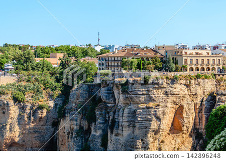 The picturesque town of Ronda in Spain is located on a cliff. The picturesque town of Ronda in Spain is located on a cliff. 142896248