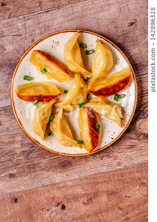 Dumplings served on a plate with green onions Dumplings served on a plate with green onions 142896328