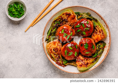Delicious meatballs served with cooked cabbage bok choy. Delicious meatballs served with cooked cabbage bok choy. 142896391