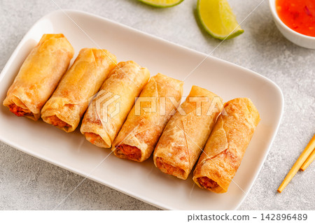 Fried spring rolls served with lime and sauce 142896489