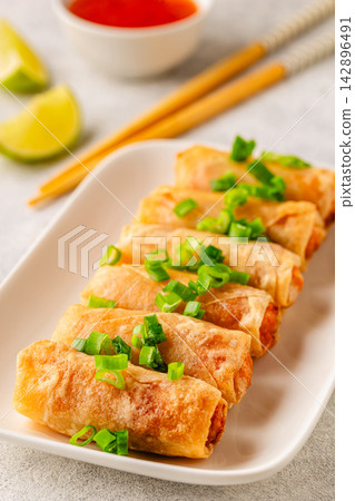Fried spring rolls served with lime and sauce 142896491