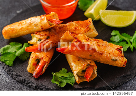 Fried spring rolls with shrimps served with sauce and lime 142896497