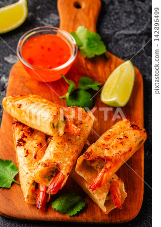Fried spring rolls with shrimps served with sauce and lime 142896499