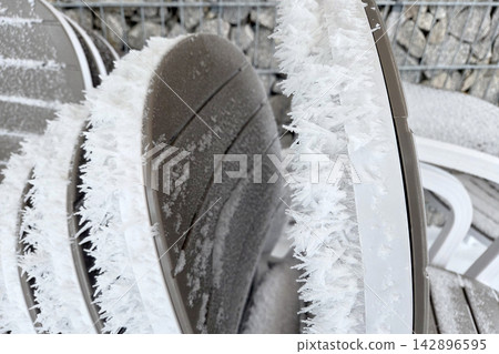 Frost-Covered Chairs in Winter Landscape Highlighting Cold Weather Patterns Frost-Covered Chairs in Winter Landscape Highlighting Cold Weather Patterns 142896595