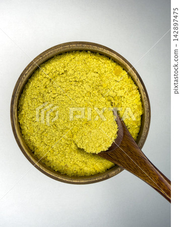 Nutritional Yeast Flakes in Wooden Bowl With Spoon, Savory Vegan Seasoning and Plant Based Food Ingredient on White Background Nutritional Yeast Flakes in Wooden Bowl With Spoon, Savory Vegan Seasoning and Plant Based Food Ingredient on White Background 142897475