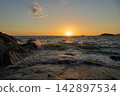 [Nishiura Coast] Sunset sinking below the horizon and waves crashing on the shore 142897534