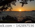 [Nishiura Coast] The silhouette of the pedestrian bridge against the sunset sinking below the horizon. 142897536