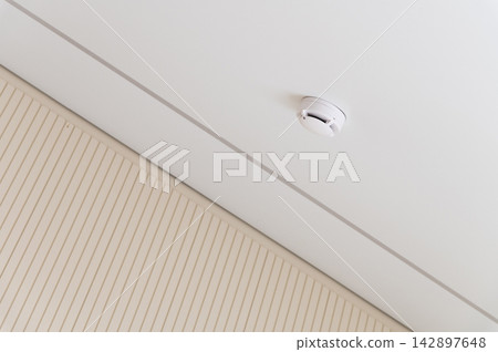 Smoke detector mounted on a white ceiling Smoke detector mounted on a white ceiling 142897648