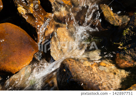 Water Flowing Over Rocks in a Stream Water Flowing Over Rocks in a Stream 142897751