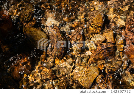 Clear Water Flowing Over River Rocks Clear Water Flowing Over River Rocks 142897752
