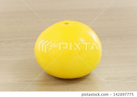 Tosa Buntan (pomelo), whole fruit, wood grain background Tosa Buntan (pomelo), whole fruit, wood grain background 142897775