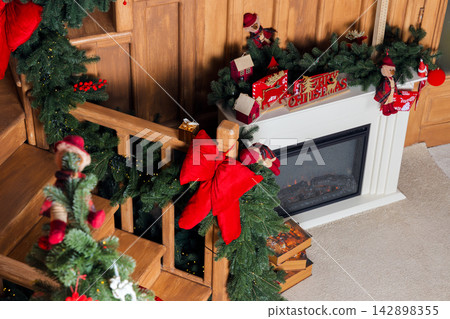 Cozy cottage interior decorated for Christmas with a fireplace and festive holiday ornaments Cozy cottage interior decorated for Christmas with a fireplace and festive holiday ornaments 142898355