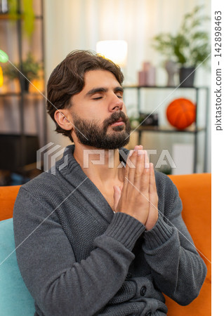 Indian man with closed eyes whispers prayer quiet ask calm mood peaceful hope hands gesture softly Indian man with closed eyes whispers prayer quiet ask calm mood peaceful hope hands gesture softly 142898463