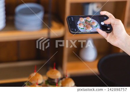 雙手正在為一頓飯拍照 142898757