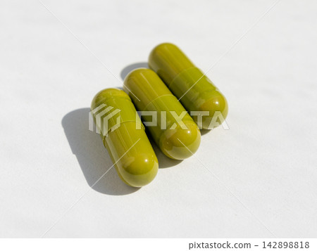 Green pills, herbal medicine capsules with herb powder Green pills, herbal medicine capsules with herb powder 142898818