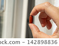 Brown gel pills, dark red capsules close up 142898836