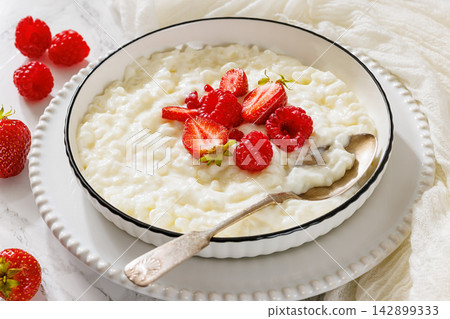 Rice porridge in a bowl topped with berries Rice porridge in a bowl topped with berries 142899333