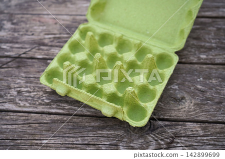 Molded fiber green egg crate template on old vintage planks background layout Molded fiber green egg crate template on old vintage planks background layout 142899699