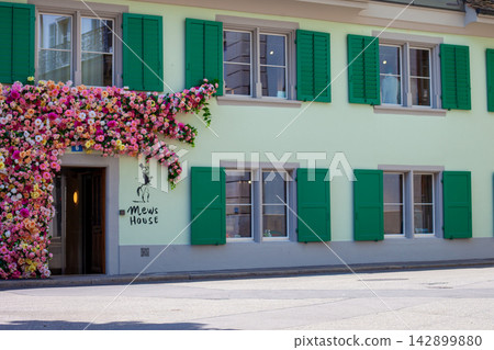 Floral Decorated Facade of Mews House Storefront with Green Shutters in Zug Switzerland Floral Decorated Facade of Mews House Storefront with Green Shutters in Zug Switzerland 142899880