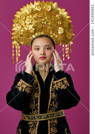 Traditional Golden Headdress And Embroidered Velvet Robe Portrait Of A Young Indonesian Asian Woman In Studio 142899881