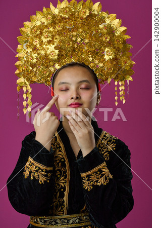 Portrait Of Indonesian Asian Girl Wearing Ornate Golden Headdress And Embroidered Traditional Costume Portrait Of Indonesian Asian Girl Wearing Ornate Golden Headdress And Embroidered Traditional Costume 142900004